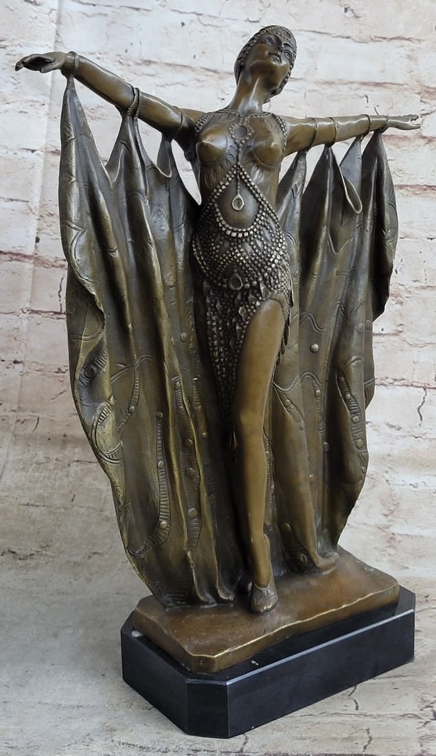 Belly Dancer Bronze Sculpture: The exotic dancer spreads her arms like a butterfly fluttering open its wings. A fabric hangs from her arms, the way a curtain falls, that sways to the movement of her dance. Great detail is seen in h
