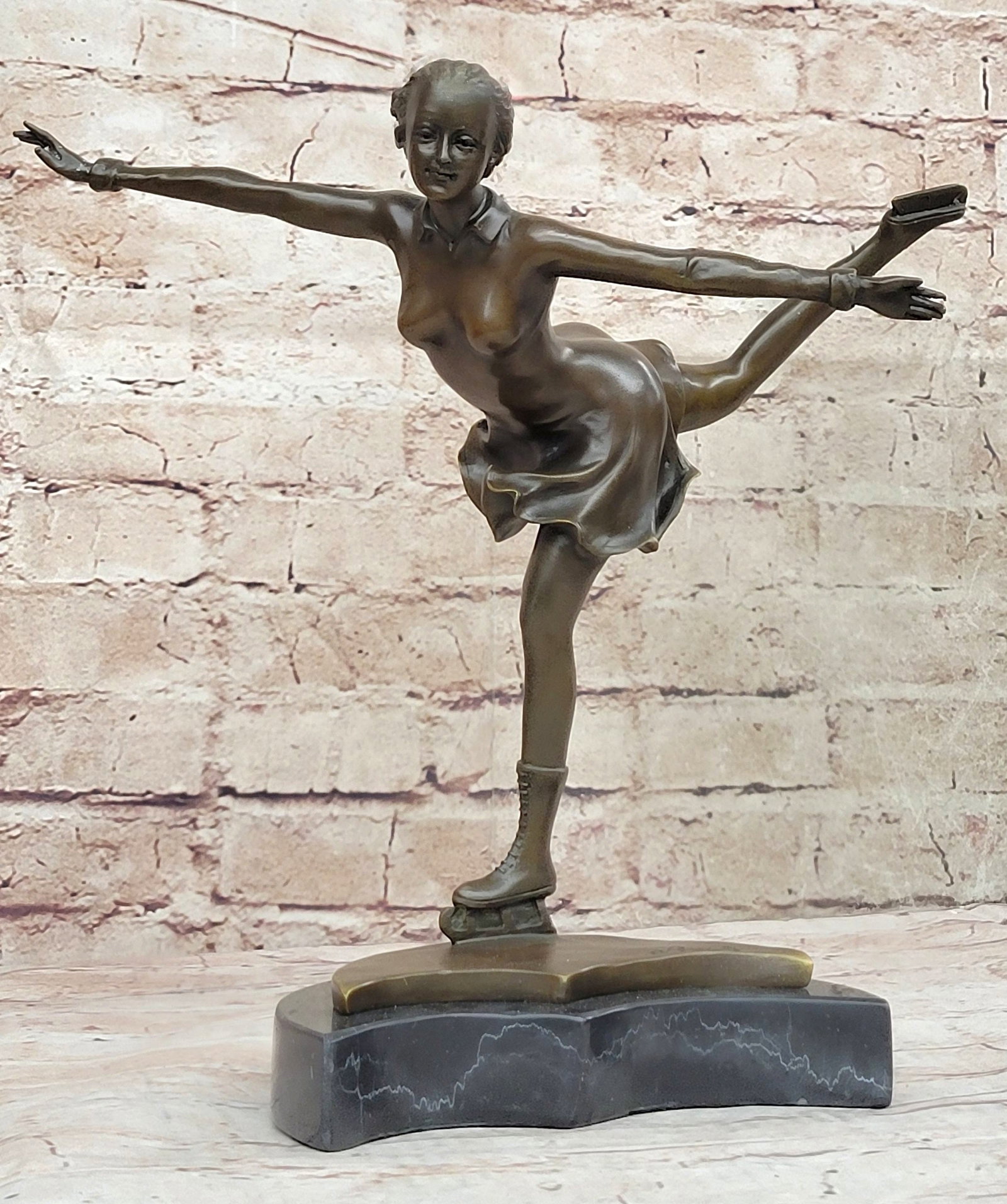 Olympic Sport Ice Skater Bronze Sculpture: A lovely lady puts on a show. Well trained in the art that she loves, she shows off her agility, balance, and flexibility. She elevates her long lean leg far behind her. Her fingertips graze her calf