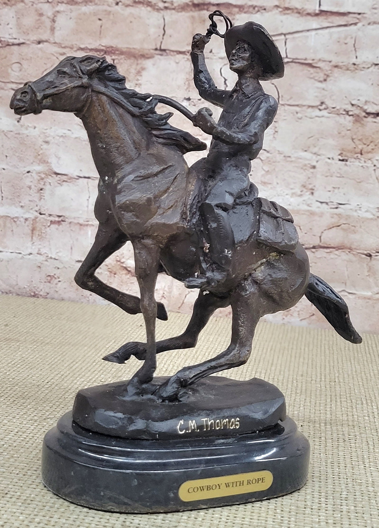 Cowboy on Horse Western Old West Bronze Sculpture: A seasoned cowboy courageously rides his wild horse. His body rolls with every move of the horse. He is dressed in a shirt, chaps, and boots. The horse saddle stays secure as he kicks leaps. Though th