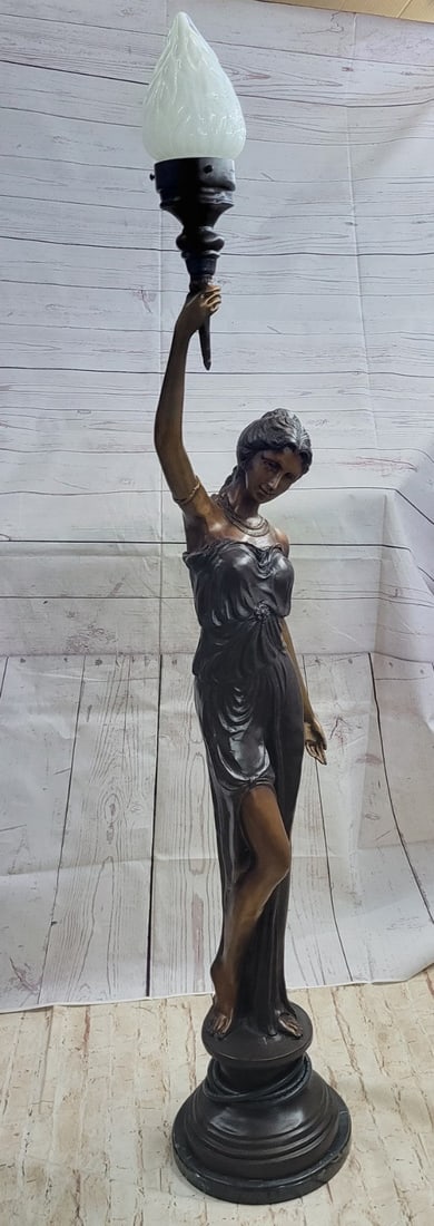 Floor Lamp Bronze Sculpture: Dressed in a gorgeously clad robe she holds up a torch in order for her to see her way through the night. Her robe is tied in place with a brown ribbon that is tied around her waist. Her curly hair