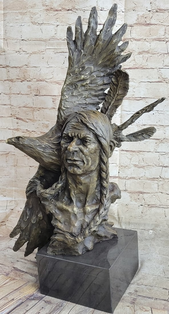 Indian Native Chief Eagle Bust Sculpture on Marble Base Statue: The Native American shaman, or medicine man, stands looking at something lost in the faraway horizon, bracing his head against an eagle that soars with open wings. Eagle feathers assist shamans in con