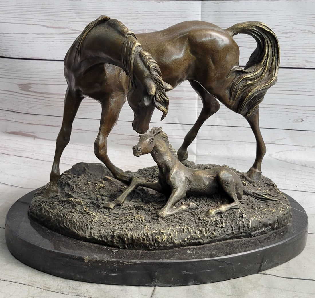 Horse and Colt Bronze Sculpture: The mother mare, though legs wobbling, excitedly bends her neck down to touch nose with her newborn creation. The young foal lays with sprawled legs that eventually one day will carry her across the