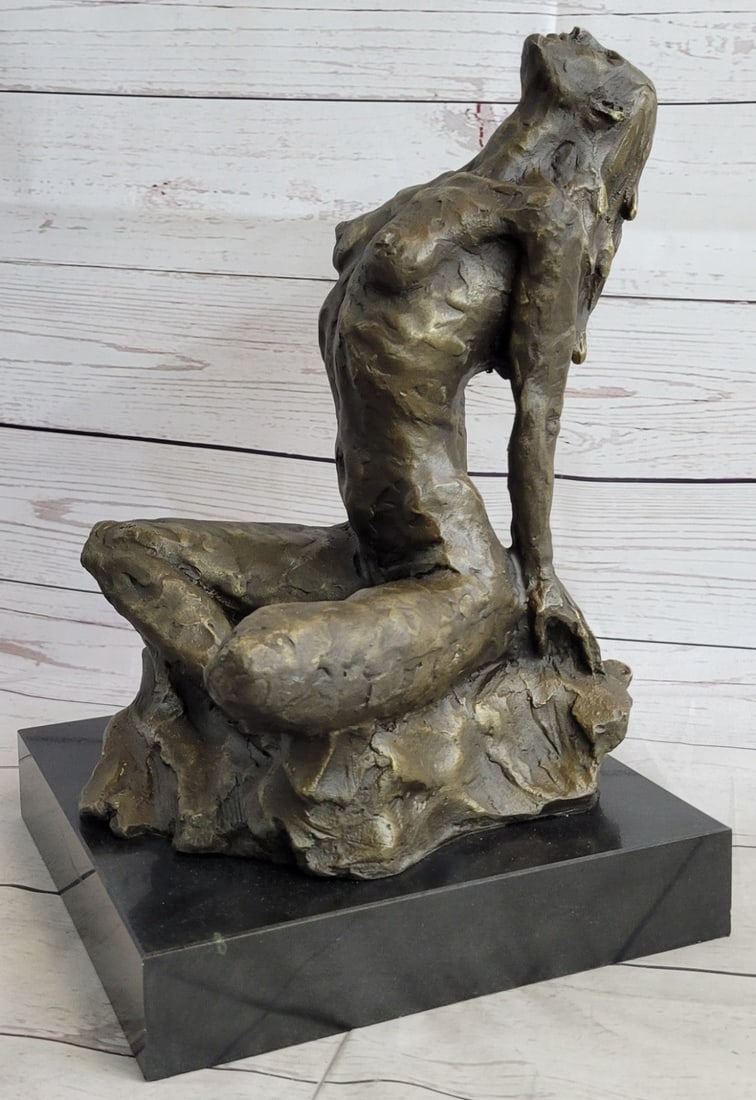 Nude Female Bronze Sculpture: She sits crossed-legged in a lotus position, her head thrown back and her back is arched in pleasure. The nude woman places her hands behind for support. The rawness of this sculpture is heightened by