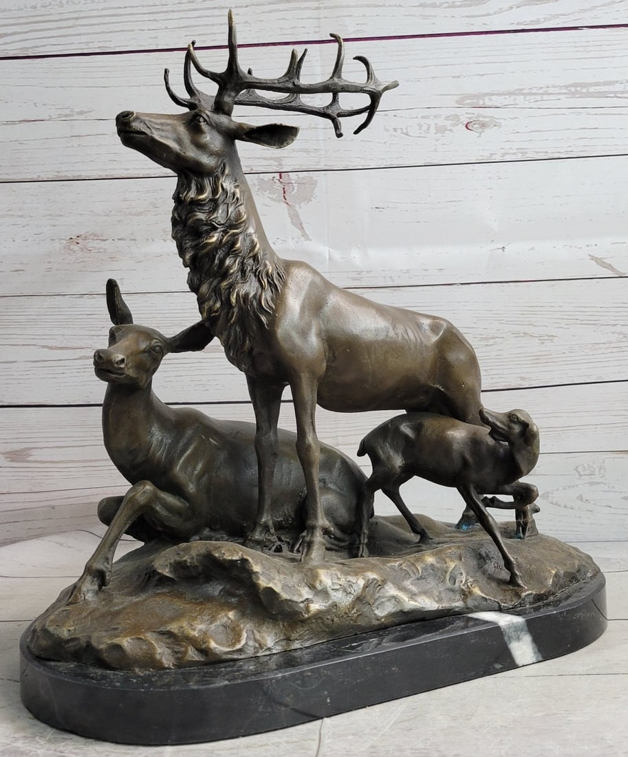 Deer Fawn Stag Buck Family Bronze Sculpture: A wonderful image it is to see a family in nature. The doe, buck, and fawn form this beautiful sculpture. The male deer stands majestically with his head held high and proud. The female rests on the g