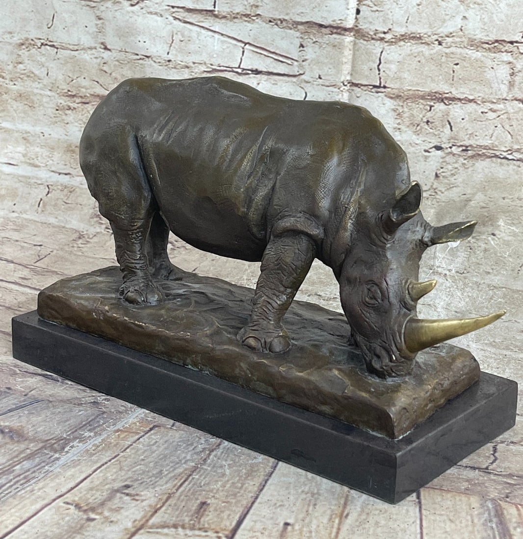 Animal Edition Rhinoceros Bronze Sculpture: The ancient and critically endangered Rhinoceros are seen foraging for food among the vegetation of the plains. The animal symbolism of the rhinoceros includes agility, solitude, wisdom, paradox,