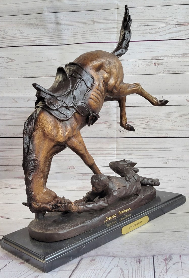 Wicked Pony Bronze Sculpture: A cowboy is bucked and dragged by his uncontrollable bronco. He attempts to hold on as long as he can but the rugged earth beneath him tears at his clothes. He is dressed in a shirt, chaps, and boots.