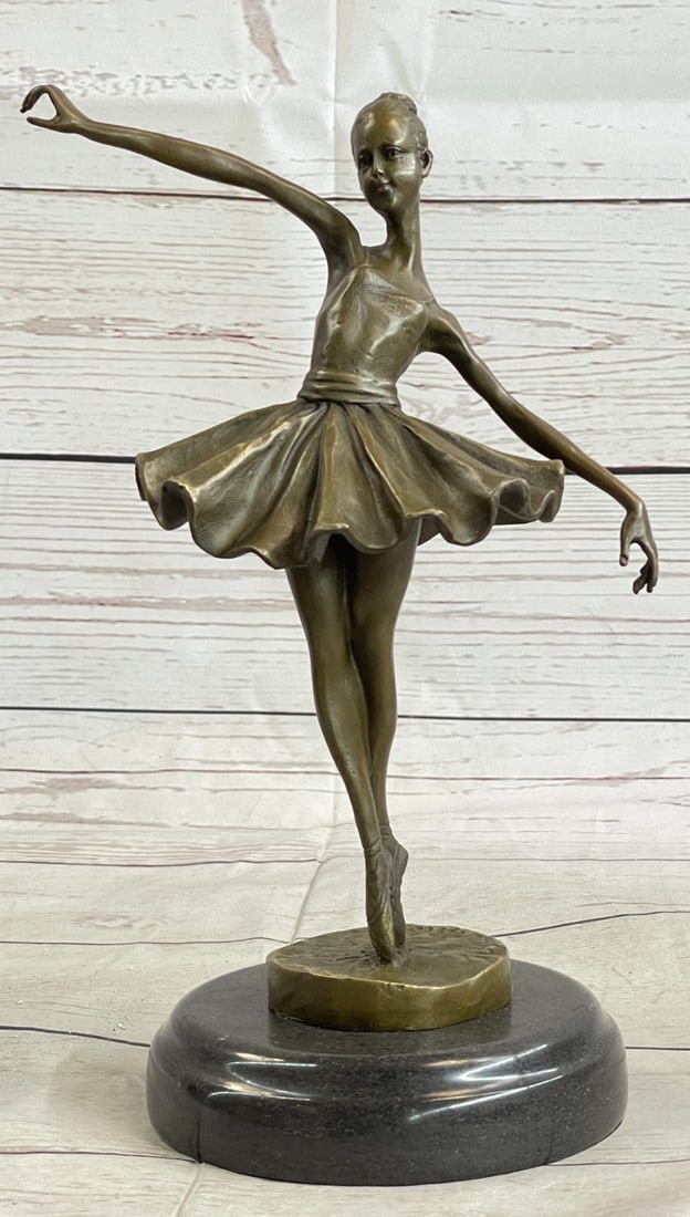 Graceful Ballerina Ballet Bronze Sculpture: The ballerina stands tall and elegant as she looks to the heights of the balcony lovingly admiring the audience. She wears a tiara and a modern tutu, the classic costume of the ballet dance, which