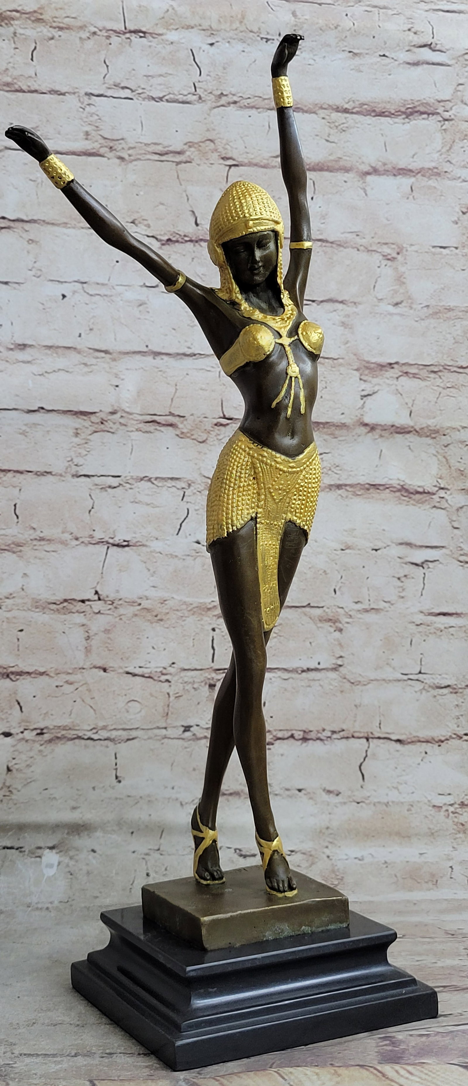 DANCER BRONZE SCULPTURE: With grace, agility, and flexibility, this vibrant dancer is light on her toes. Her beaded yellow patina mini skirt jiggles behind her as she shakes her hips to the music. This nimble dancer tilts