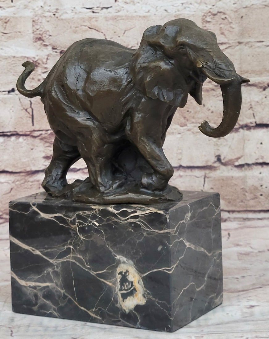 Elephant Bronze Sculpture: The elephant can be envisioned tracking slowly and majestically across the ceaseless dryness of a plain in search of a watering hole or the shade of trees. He pulls his trunk upwards. He pulls his tru