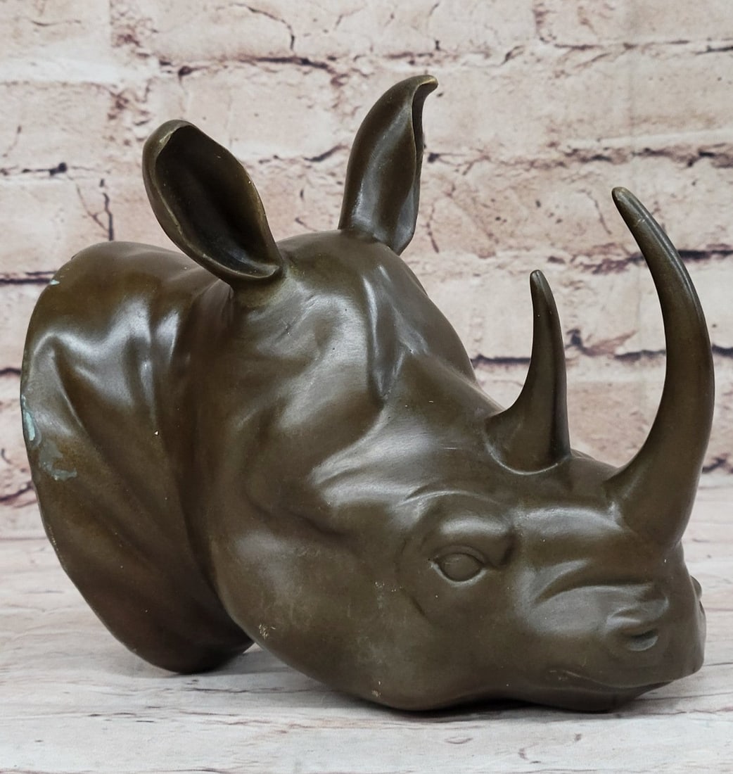 African Rhino Wall Mount Bronze Statue: A small depiction of the large and mighty Rhinoceros. The Rhinoceros head Sculpture comes ready to be hung on your wall. The careful and detailed sculpting makes it stunning and easily spotted. It