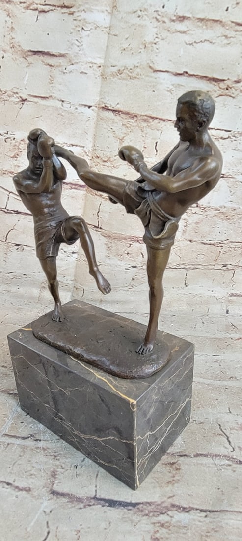 Kick Boxers Bronze Sculpture: It is the last round of the match and the odds are not looking good for one kick Boxer. He steps back in reaction to the stiff punch that has just hit his jaw. The adept boxer is weary yet he powered