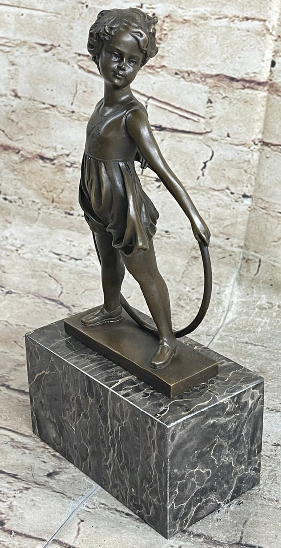 Pretty Girl playing Bronze Sculpture: There is nothing more precious than the innocence of a young child at play. After the days of late-night bottle feedings and before the pouty dog days of the terrible teens, there are the sweet