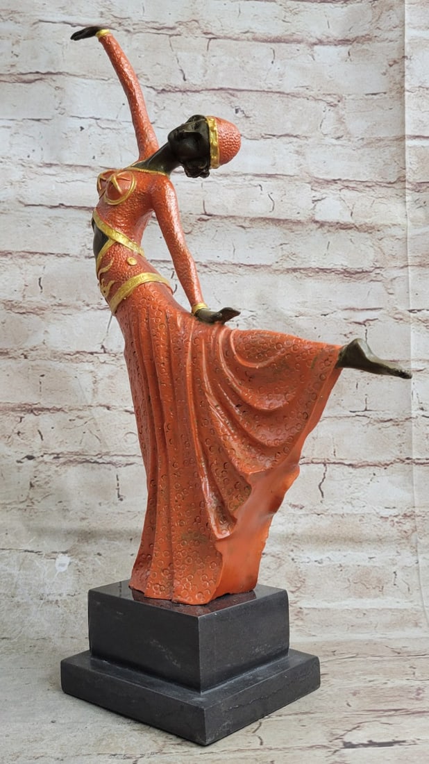 Dancer with Striking Pose Bronze Statue: An elegant dancer extends her long leg out in an arabesque. Her long vibrant dress extends with her. She raises softly and gently to the sky. Her head tilts along with the movement. This a very