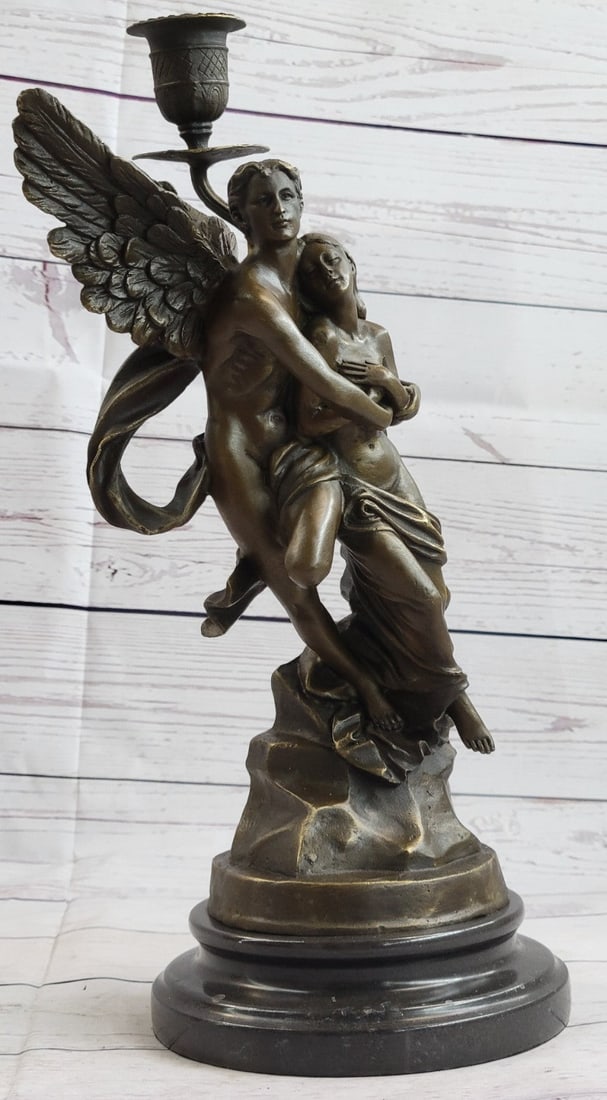 Eros and Psyche Romantic Candle Holder Bronze Sculpture: A nude male angel carries a nude girl and in his arms. The girl clutches her bare chest as she head tilts up to her lover and protector. They are almost nude with only a cloth lightly draped over the 