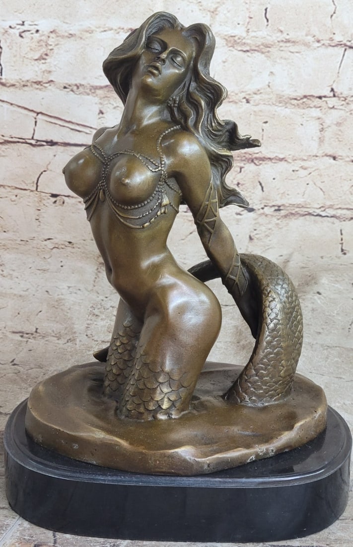Mermaid Bronze Sea-life Sculpture: Sea-life Sculpture of a realistic mermaid sitting while holding her tail. The mermaid Sculpture is also designed for placement on a shelf to brighten up the room. This brown Bronze patina was crafted 