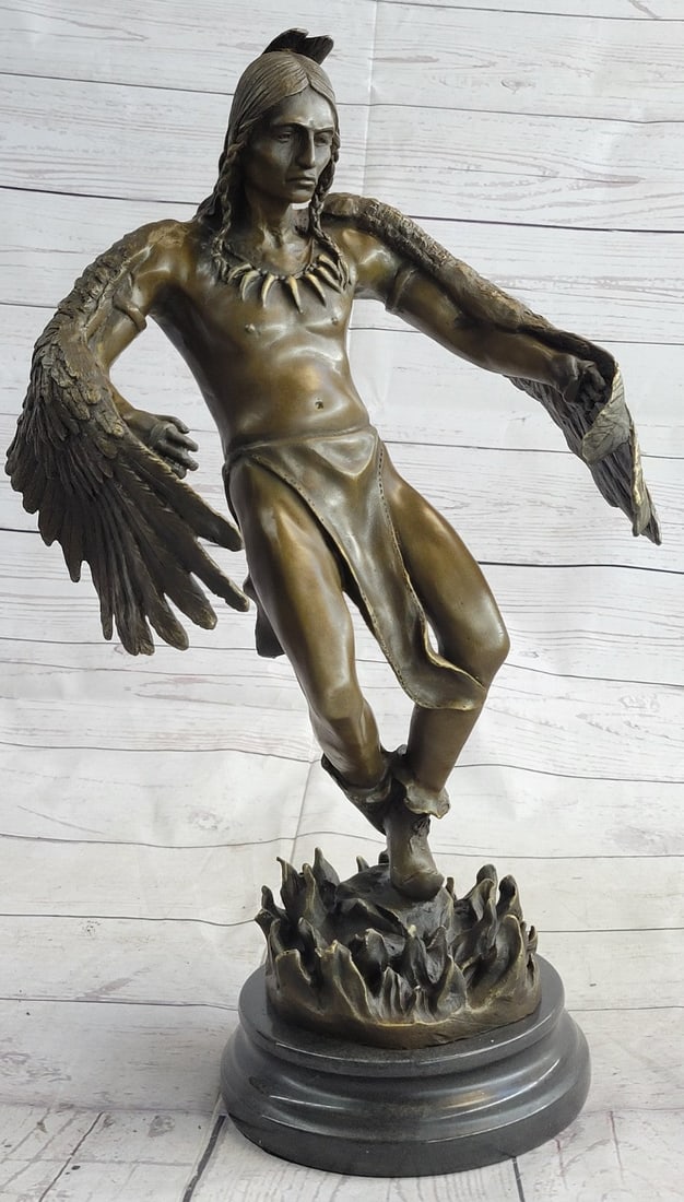 American Indian Warrior Bronze Sculpture: This Sculpture of a Native American man who believes in the power of bird wings takes pride in his creation. He is standing with nothing but a cloth on his lower region and he is looking down as he fe