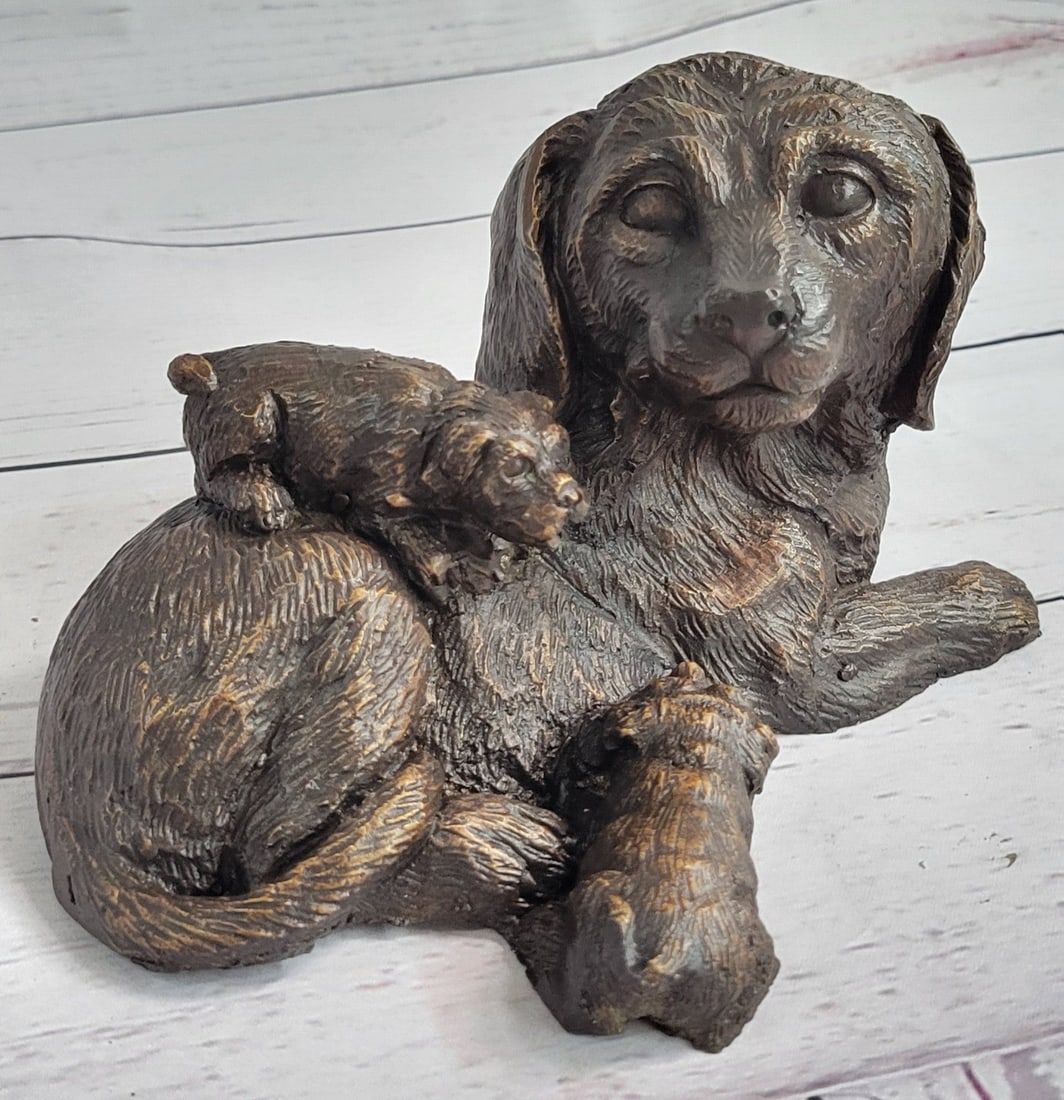 Dog Labrador Retriever Animal Bronze Sculpture: Mother love is a universal concept between mankind and wildlife. In this sculpture, a puppy cuddles up against his mother to drink milk. He nuzzles his head beneath her, while his sibling crawls over