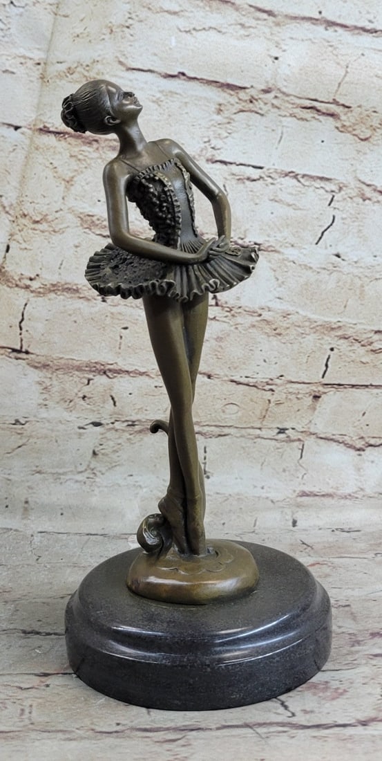 Balanced Ballerina Bronze Sculpture: A prima ballerina puts on a show. Well trained in the art that she loves, she shows off her agility, balance, and flexibility. She elevates her long leg far behind her. Her chest pushes out and her
