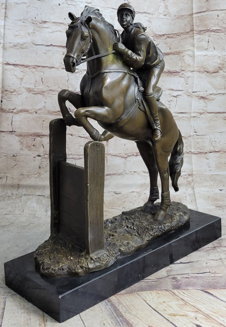 Female Jockey Jumps Bronze Sculpture: This figurine displays a jockey riding her racehorse after a race.?She sits in a relaxed position with both hands on her horse rope as her majestic creature towers under her in proud stance. The