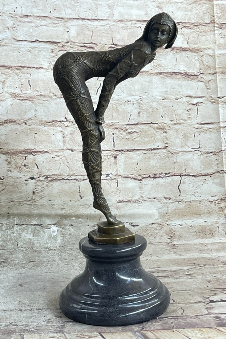Woman in Seductive Pose Bronze Sculpture: The alluring woman is captured in a seductive pose as she bends her upper torso, hands resting on her knees, as her figure takes an L-shape. From her head to her dainty pointed toes, she wears a strap
