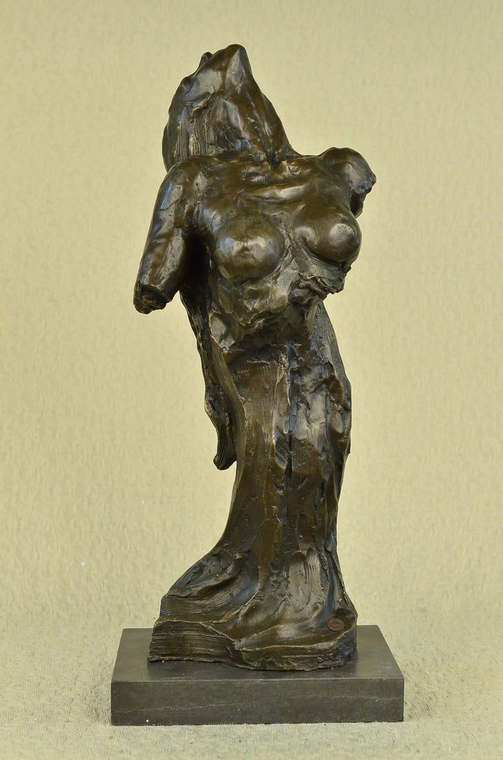 Nude Female Bronze Sculpture: The woman's bust emerges from the wood. This abstract sculpture has created the female form in a natural setting. The rest of the sculpture resembles an elongated tree stump. There is no doubt that th