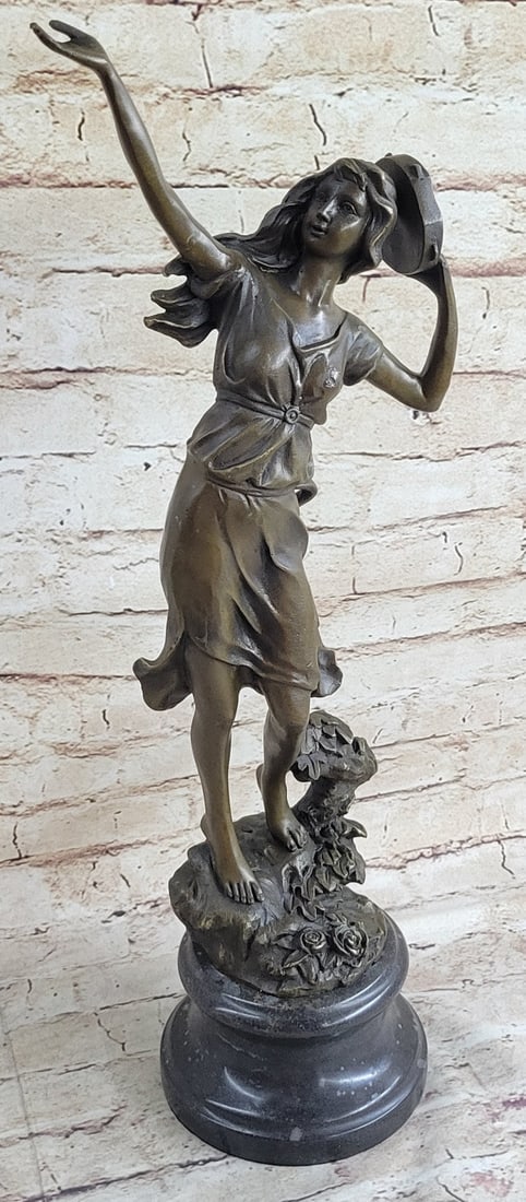 Turkish Woman playing Tambourine Bronze Sculpture: Calling to the winds above the young woman looks to the sky and taps her tambourine to her head. Her long hair and dress flow from the soft breeze of the wind. She stands barefoot out on the land amid