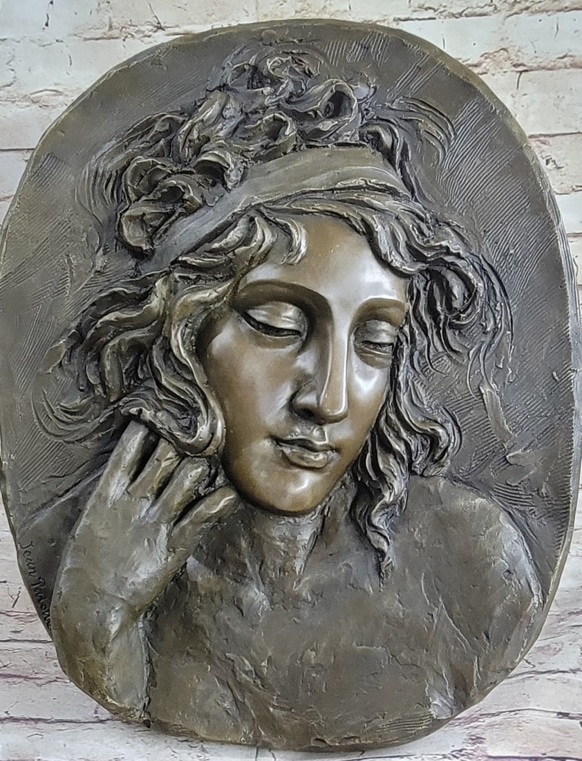 Woman Face Bas Relief Wall Mount Bronze Sculpture: This beautiful wall piece depicts a the profile a young woman. Her expression is solemn. Her hair hare is styled in soft waves. This elegant piece will add class and style to any living room, dining