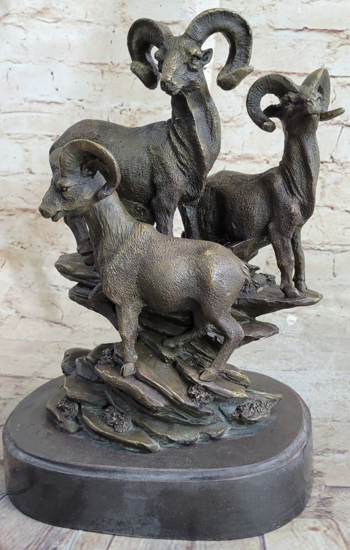 Group of Ram on a Cliff Bronze Sculpture: These three Rams rest on the high cliffs of a mountain in a carefree manner. This bronze sculpture was cast using the age-old method of lost-wax casting and stained with a brown patina finish for