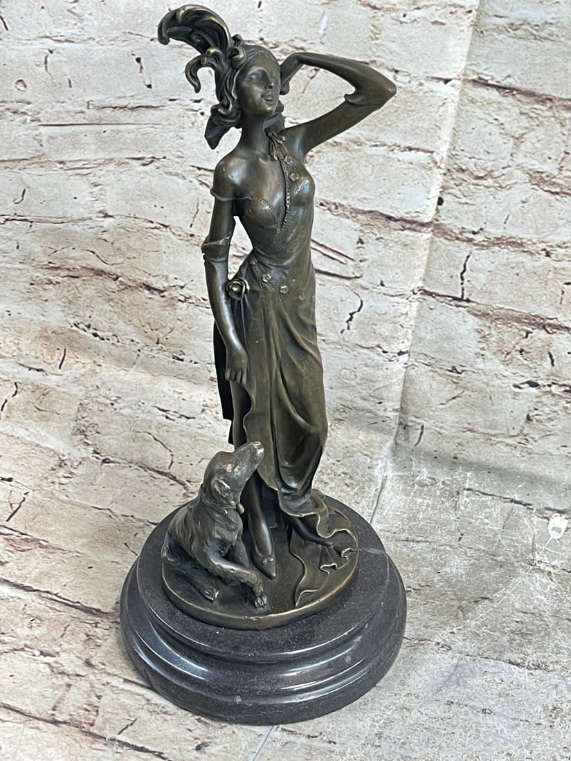 Nude Female and Dog Bronze Sculpture: This is a wonderful statue of a woman with her dog. The woman is middle-aged and fancily dressed. She is wearing a long beautifully detailed dress that hangs from her shoulders and has a broach under