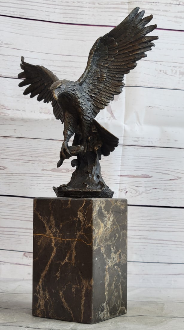Swooping Eagle Catching Fish Wildlife Bronze Sculpture: This eagle lets time pass by as he rests atop a nest, he watches carefully as his prey comes at close range. He sits peacefully and patiently as his claws are spread out giving him a perfect balance