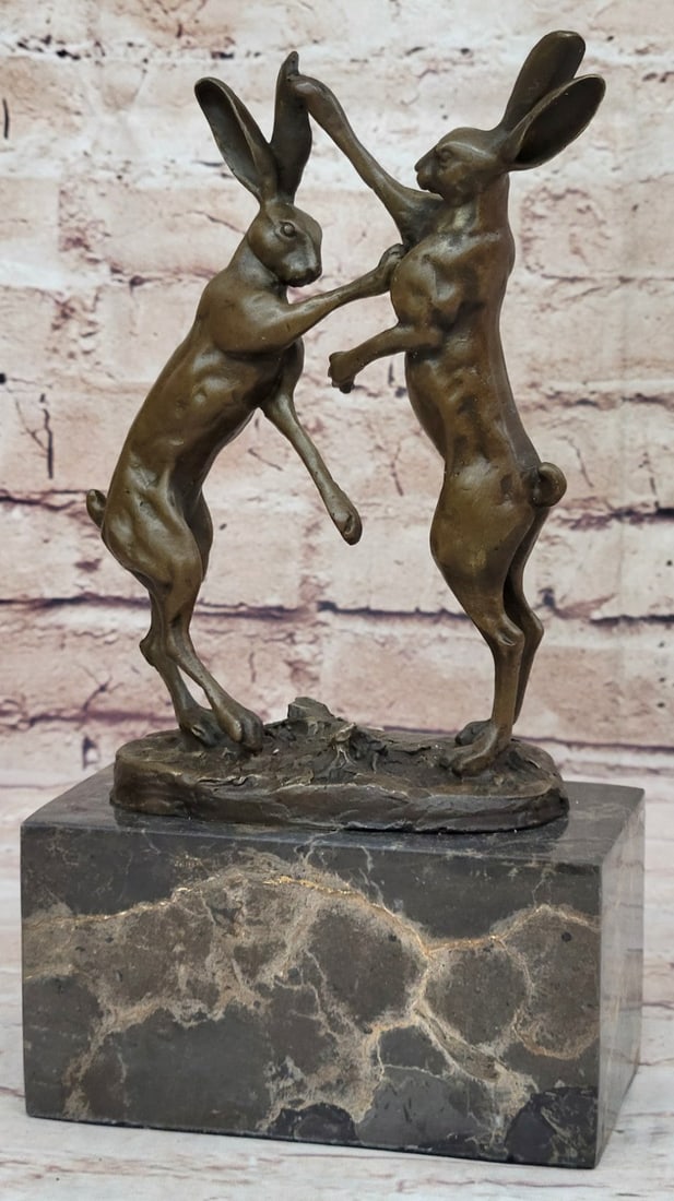 Two Hares Boxing Bronze Sculpture: Representing in a long list of fictional stories the hare is a normally a shy animal. In this Sculpture, the shyness evades the two hares as they fight with each other. The hares stand on the their
