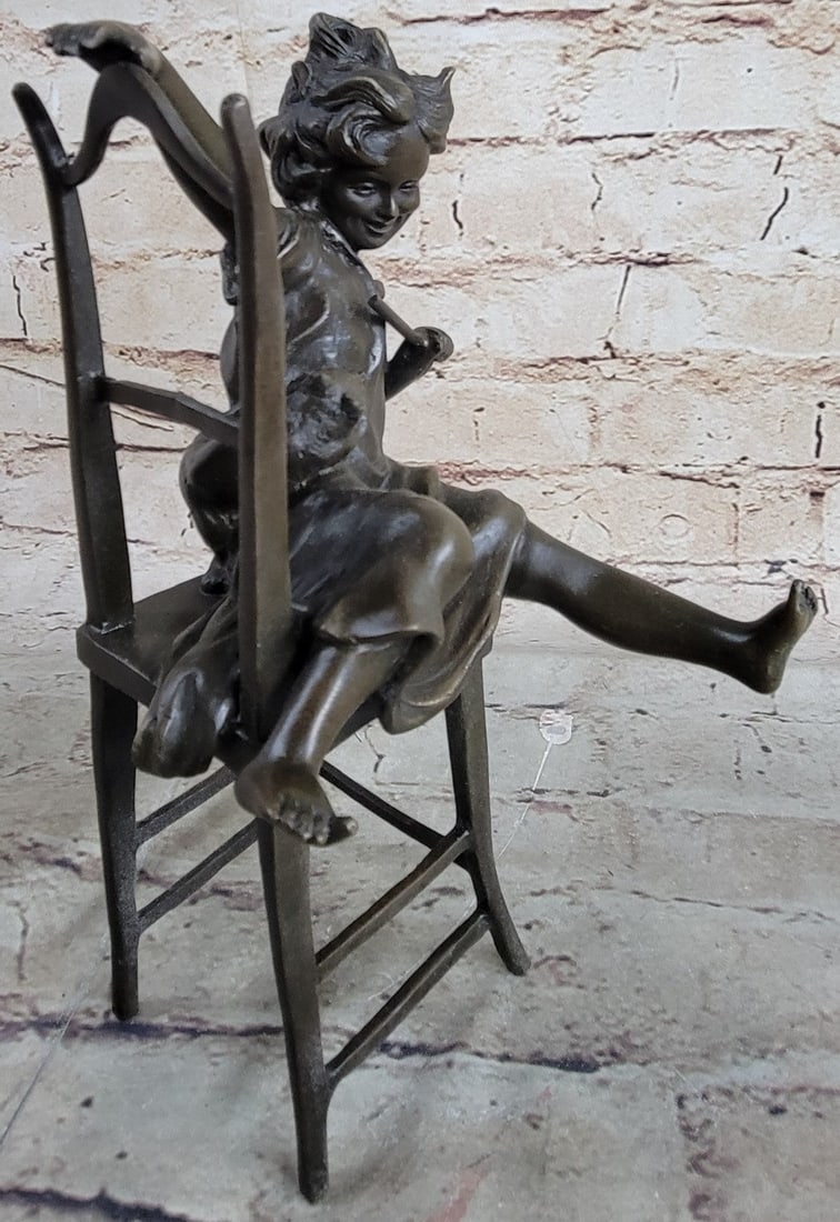 Beautiful Cat With Little Kid Bronze Sculpture: This fine Sculpture exudes joy and shows motion from every angle. It depicts the innocent joys of life simply as we know it. As the little girl sits in her chair, she playfully starts a game of