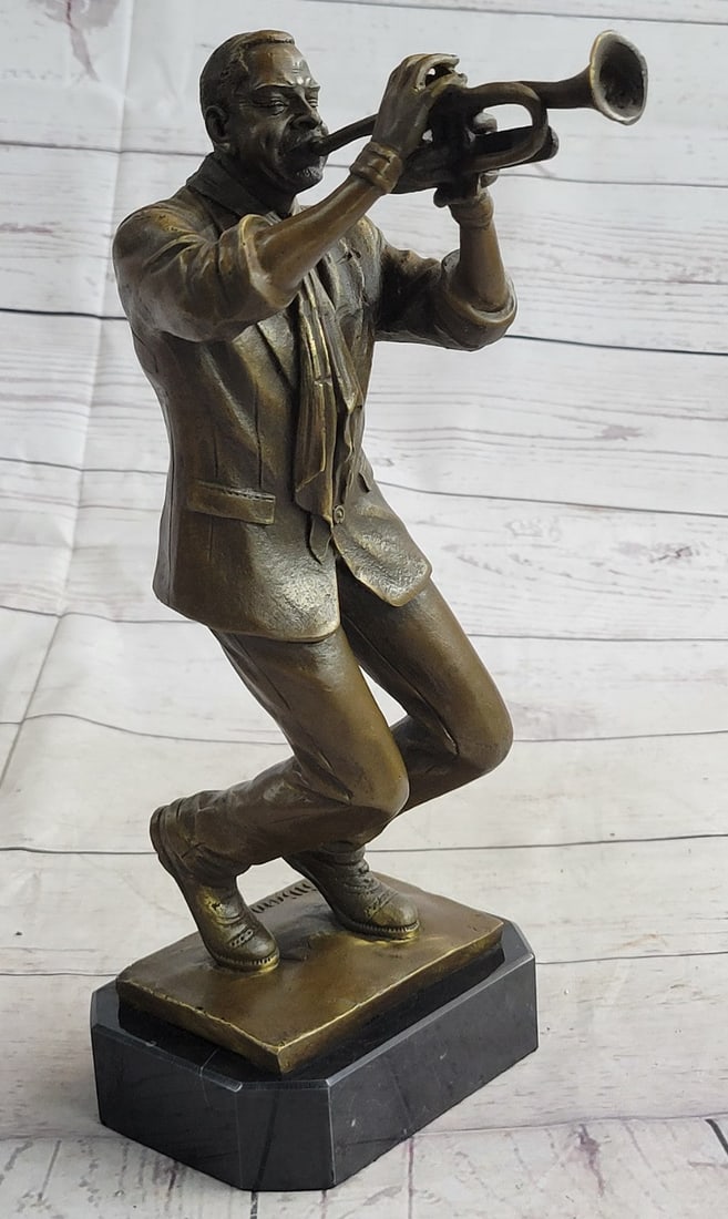 Trumpet Player Bronze Sculpture: This musician blares out notes as he plays his trumpet high in the air. He lifts his arms and bends his elbows letting his trumpet and body move as one. He wears a fitted suit jacket and a tie. This