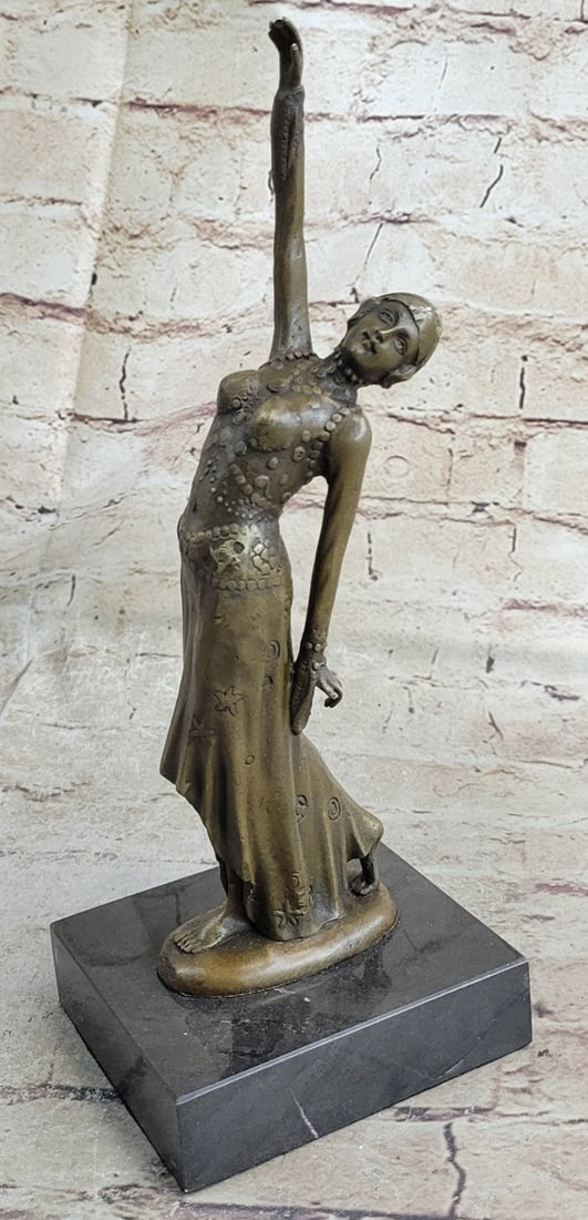 Belly Dancer Bronze Sculpture: The belly dancer presents herself with both crossed arms above her head. She tiptoes forward seductively, as the beads of her costume jangle with her movement, enticing her audience. She was captured