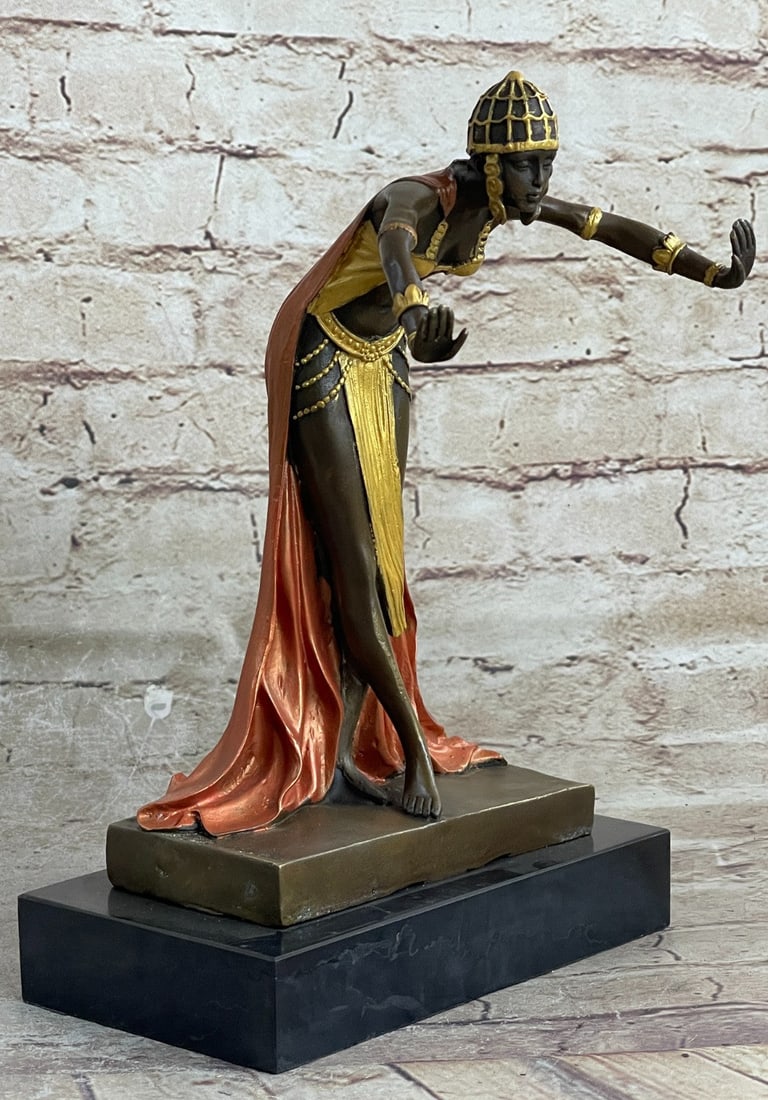 Egyptian Princess Bronze Sculpture: This Egyptian princess bows graciously with her hands out to her side as her long royal flowing dress cascades down her legs and gathers at her feet. On her head, she wears a jeweled crown that has fl