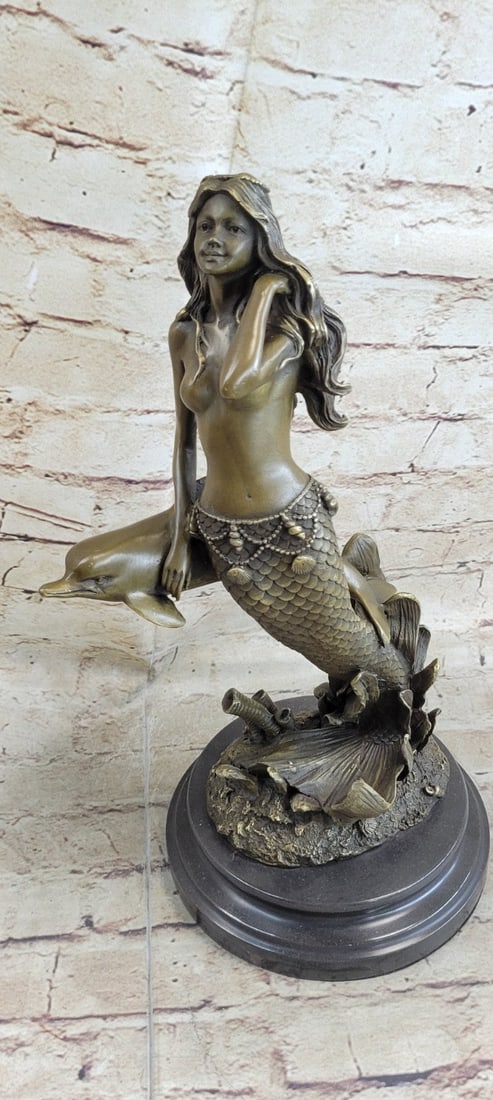 Mermaid and Dolphin Bronze Sculpture: Many people find the mystery of mermaids enchanting, and if you've spent much time out to sea. This gorgeous sculpture features a beautiful mermaid swimming with cute dolphins is expertly cast in the