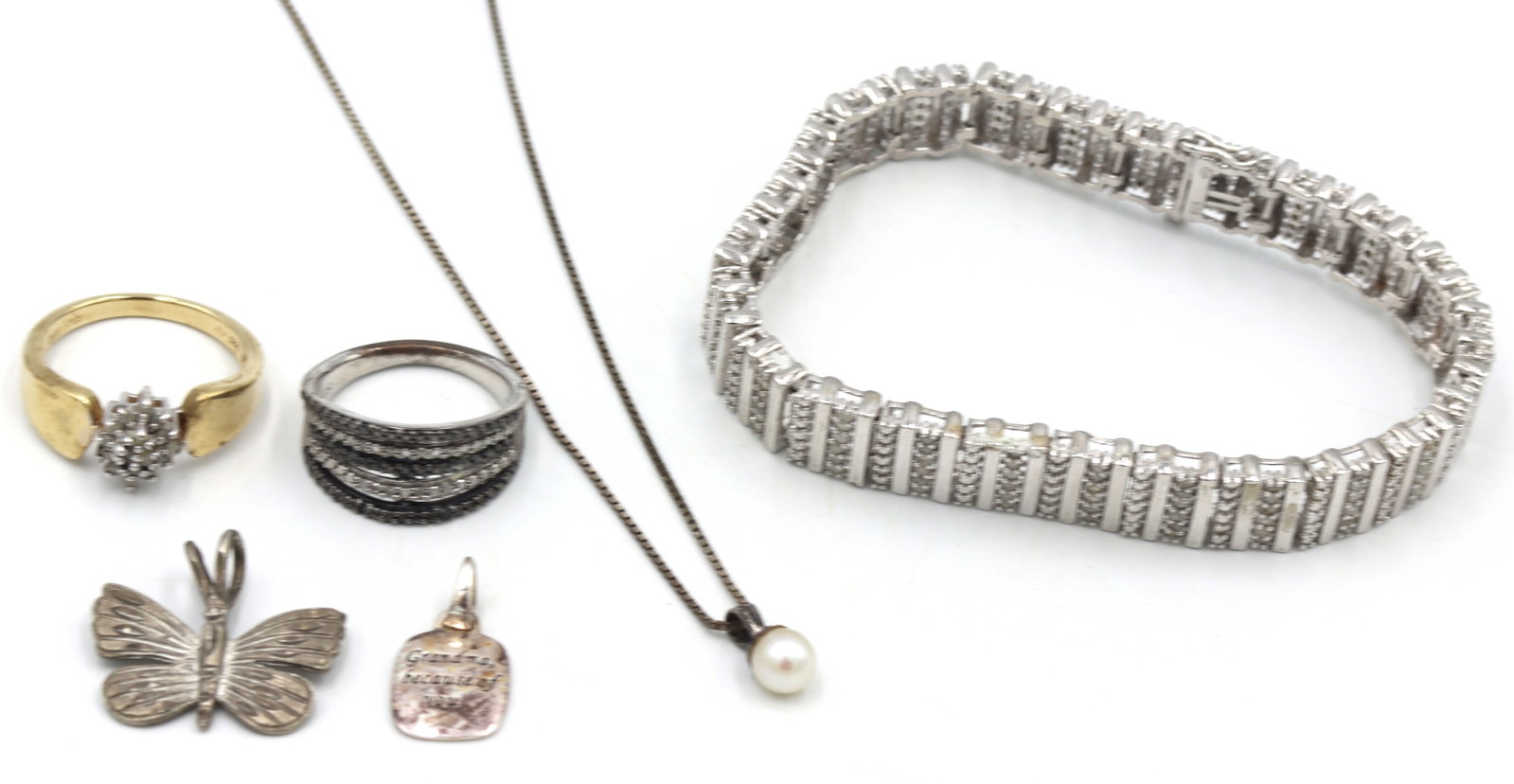 Group lot of Vintage 925 sterling silver jewelry: Group lot of Vintage 925 sterling silver jewelry.? rings, 2 charm pendants, Pearl pendant on box chain necklace and cubic zirconia tennis bracelet. The total weight of the lot is 36.10 grams.