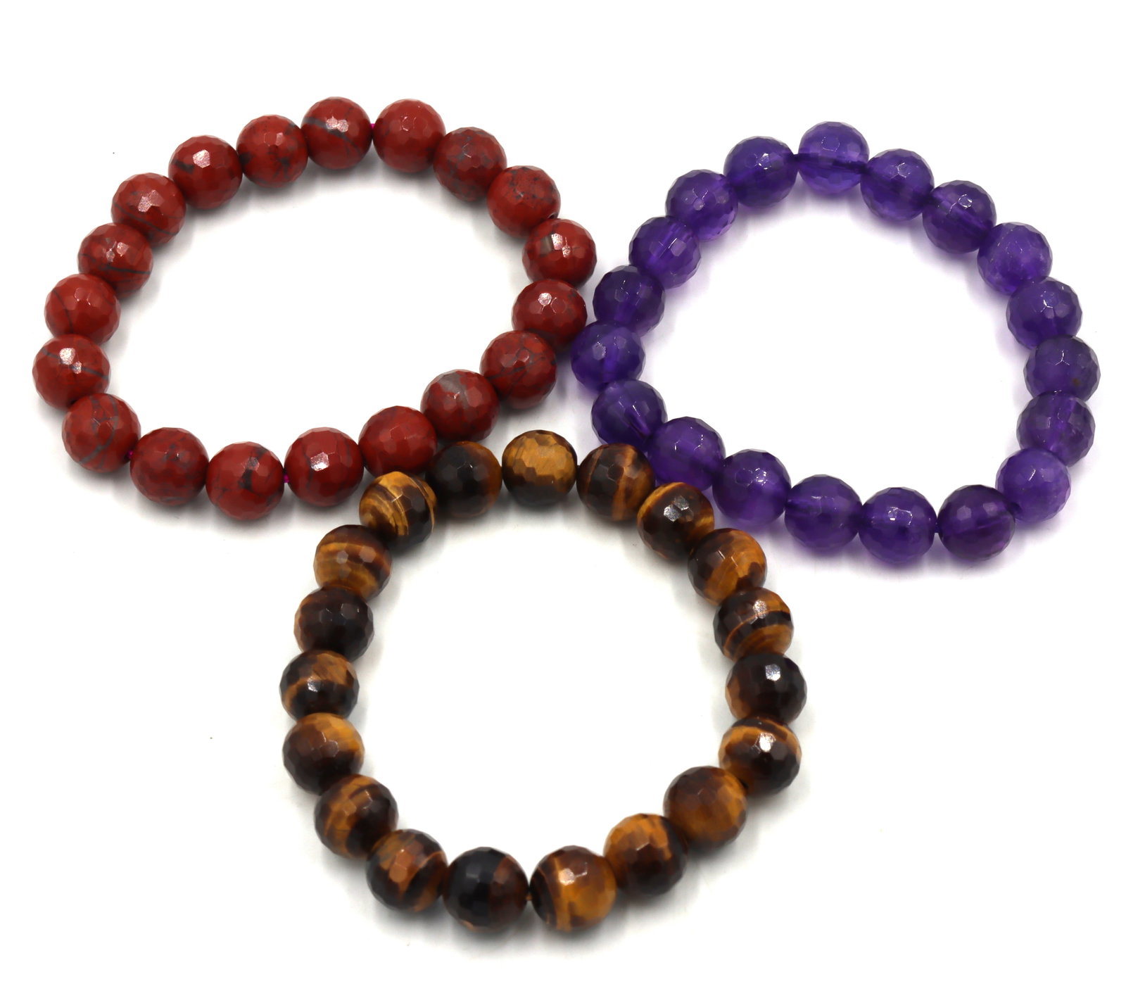 Group lot of 3 gemstone bangles: Group lot of 3 gemstone Coral, tiger eye and amethyst bangles. The total weight of the lot is 82 grams.