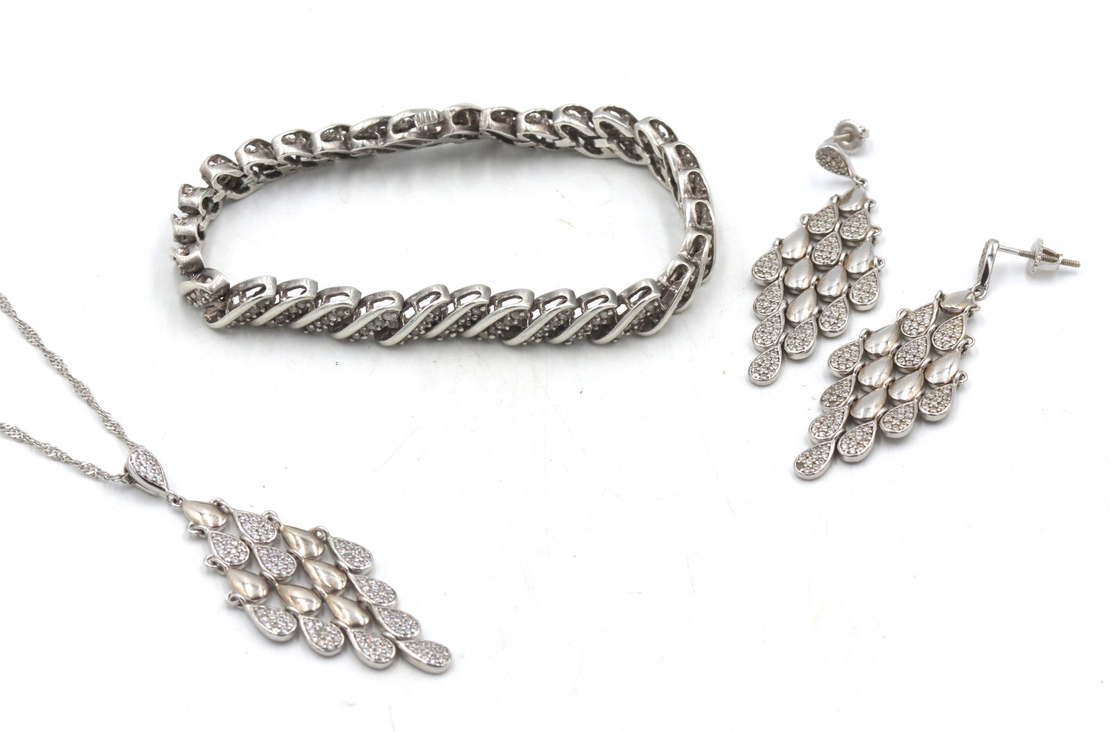 Group lot of Vintage 925 sterling silver mixed jewelry: Group lot of Vintage 925 sterling silver mixed jewelry. Diamond 7-inch tennis bracelet. Dangle earrings and matching pendant on 16-inch rope chain necklace. The total weight of the lot is 31.40 grams.
