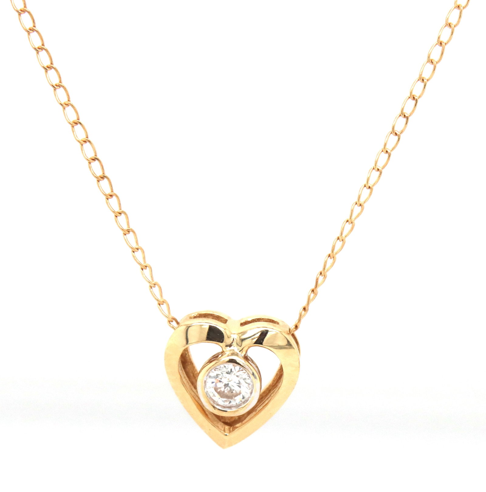 14kt Yellow gold 0.12ct bezel set diamond heart pendant on chain: 14kt Yellow gold approximate 0.12ct bezel set diamond heart pendant on 16-inch chain necklace with spring ring clasp. The total weight of the necklace is 1.50 grams.