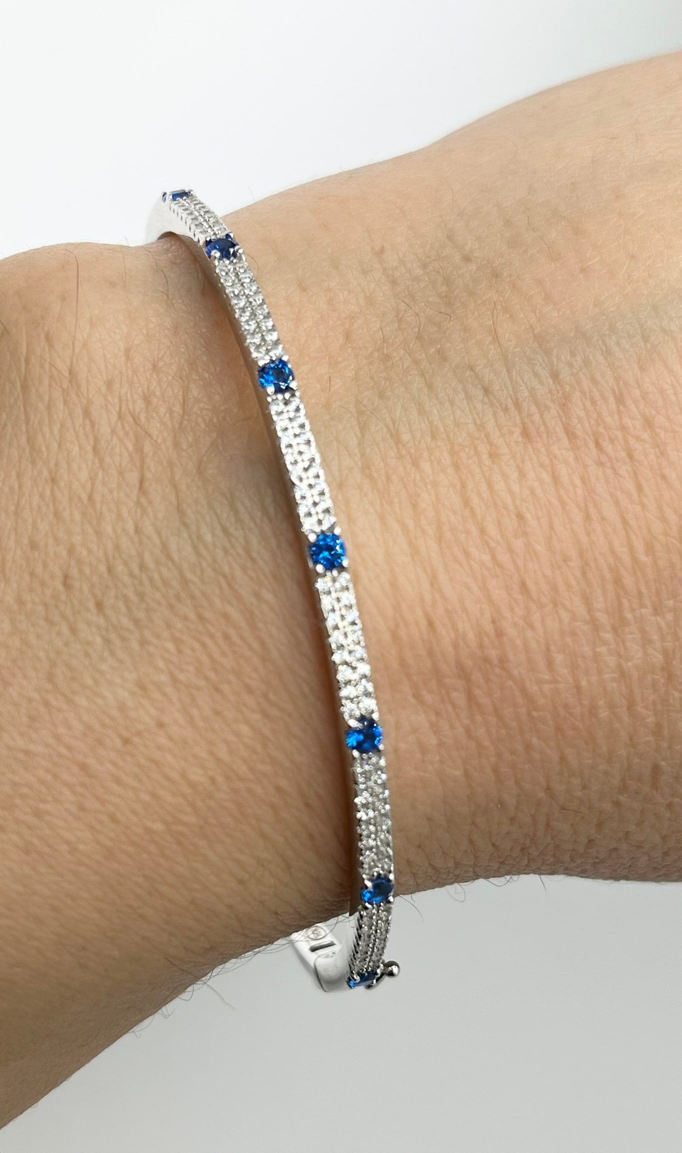 925 Sterling Silver Cubic Zirconia And Blue Stone By The Yard Bangle: 925 Sterling Silver CZ and alternating blue stone bangle. 11.2 grams size M