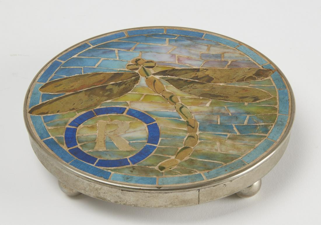 Interesting Inlaid Arts and Crafts Trivet: Inlaid Arts and Crafts Trivet. with dragonfly. Footed metal frame with mixed stone inlay. Circa 1920. Dia. 6-7/8". Excellent condition.