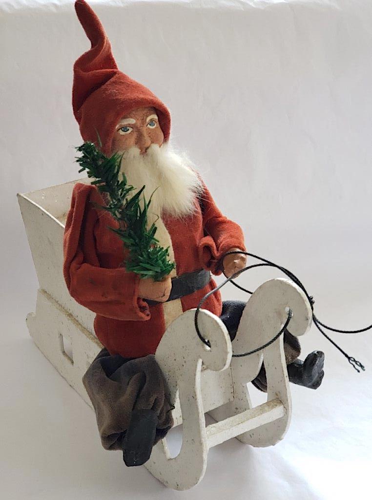 Santa in Sleigh Vintage Christmas Ornament: Santa in a Sleigh Christmas ornament. This unusual 1920-30's 10 inch Santa is in full red coat and blue pants. He has a composition face, hands and black boots and sports a rabbit fur beard. His sleig