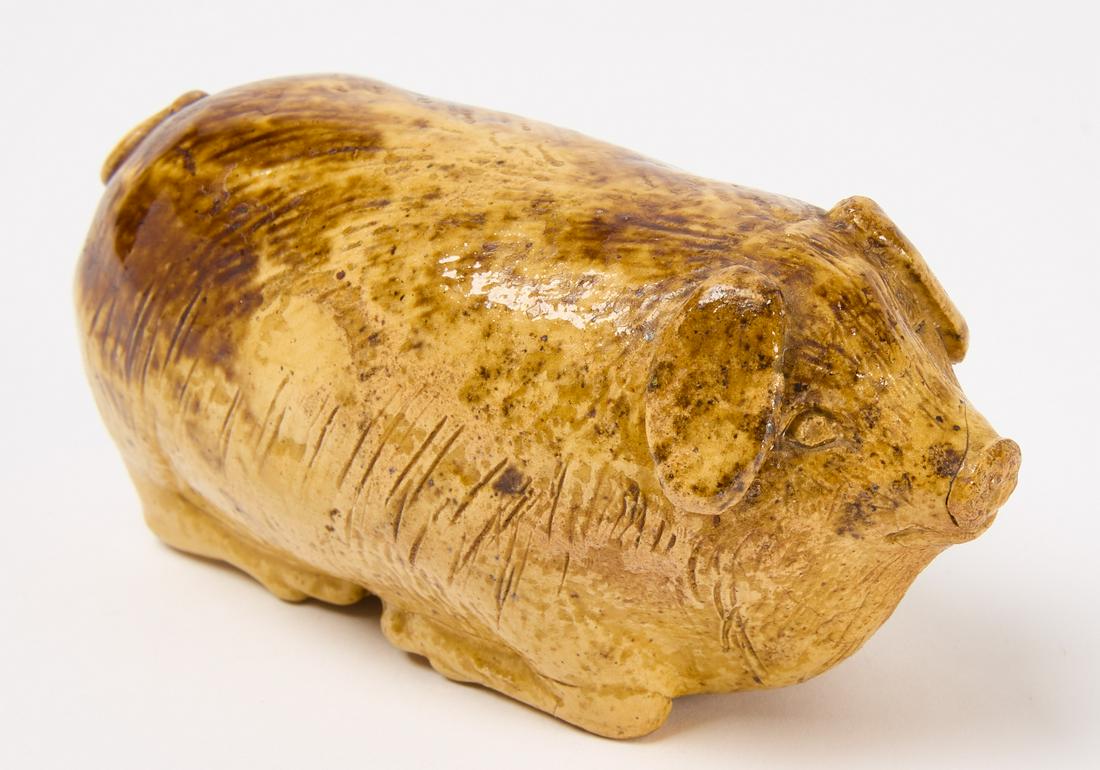 Redware Pig Flask: Redware pottery pig flask with yellow glaze and scoring detail on the surface. Pennsylvania, circa 1860. H 2-1/4" W 5" D 2-1/4". Condition: Fine original condition. Copy and paste this link for high-r