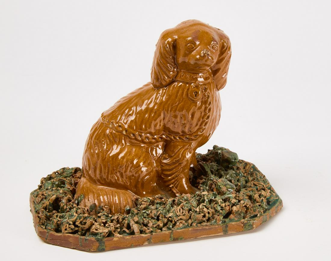 Large Redware Dog: Large redware dog sitting on a coleslaw base. Dog wears a collar with chain and lock. "Rover" is incised on the collar. Attributed to John Bell, Shenandoah Valley, Virginia, circa 1880. H 7-3/4" W 10-