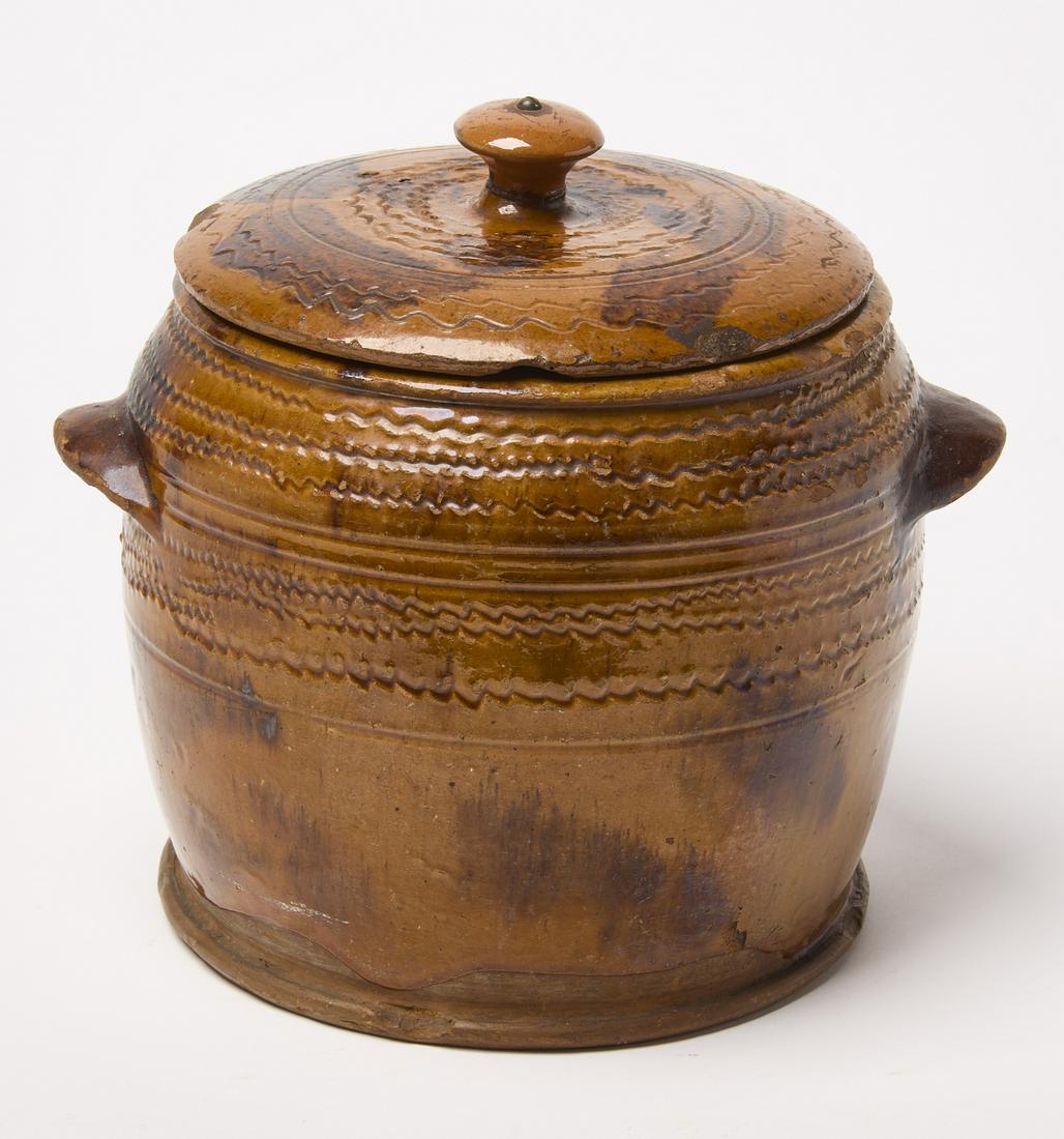 Redware Jar with lid: Redware handled jar with lid. Manganese slip decoration with incised concentric wavy line detail. Vickers Pottery, Chester Country, Pennsylvania, circa 1835. H 8-1/2" D 9-1/4". Condition: Excellent. L
