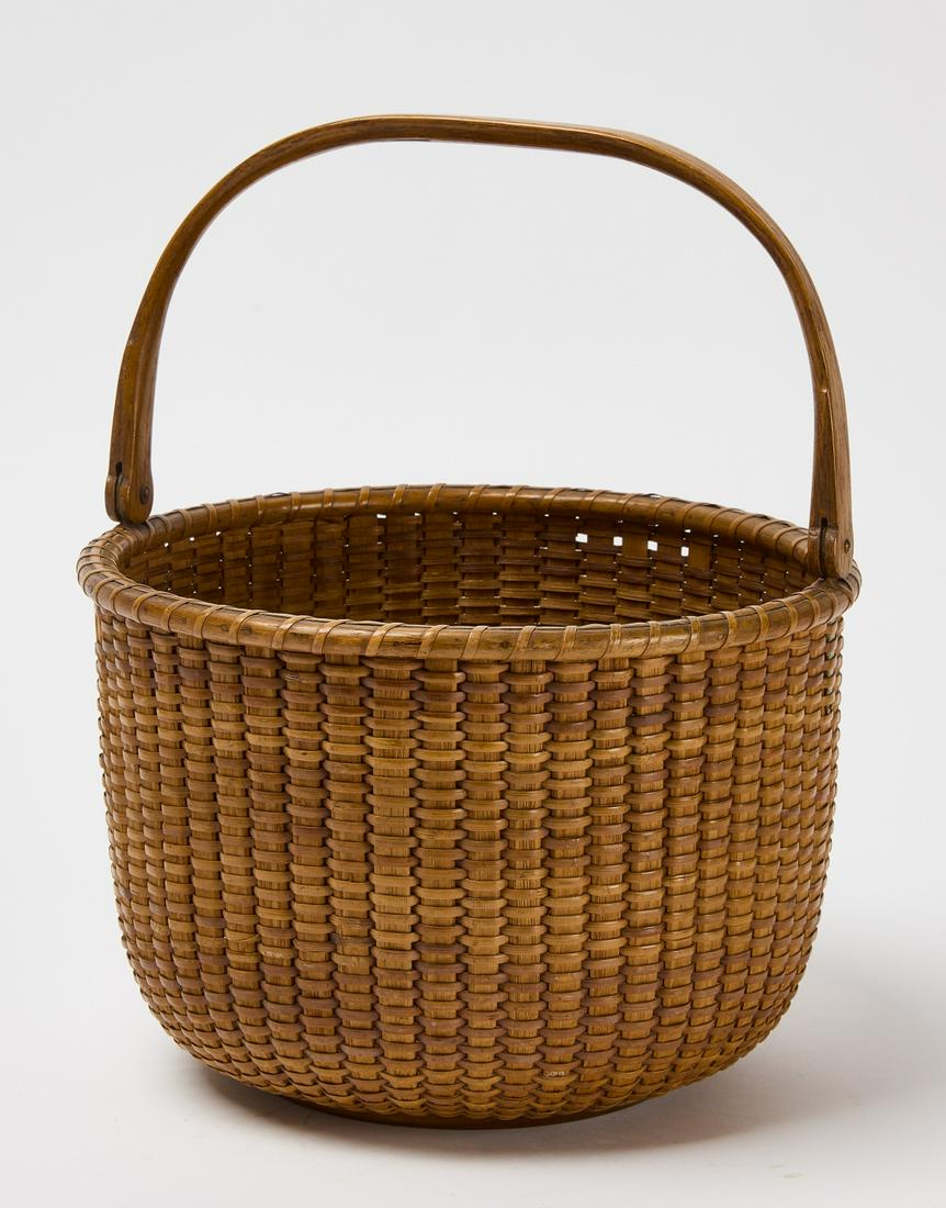 Nantucket Basket: Nantucket basket with handle. Condition: Good. Minor losses and imperfections. Refer to images. H (w/ handle) 11-5/8" H (w/o handle) 7" D 10-1/4". Copy and paste link for high-res images: https://www.