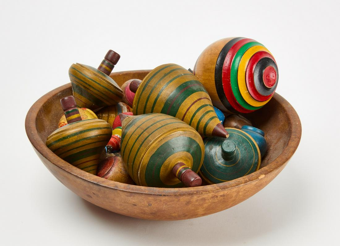 Carved Bowl With Vintage Tops: Carved bowl with vintage carved and painted folk art toy tops. 32 tops total. Late 19th century. Bowl: H 4" W 13-1/8". Tops H range: 1-7/8" to 6-3/8". Condition: Minor wear and imperfections. Link for