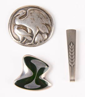 Two George Jensen Silver Pins and Tie Clip: Two George Jensen silver pins and tie clip. 1) Two birds in circular format, signed. #167, D 2". 2) Abstract organic design in silver and black, signed.#315. H 1-1/2" W 1-3/4". 3) Tie clip with floral