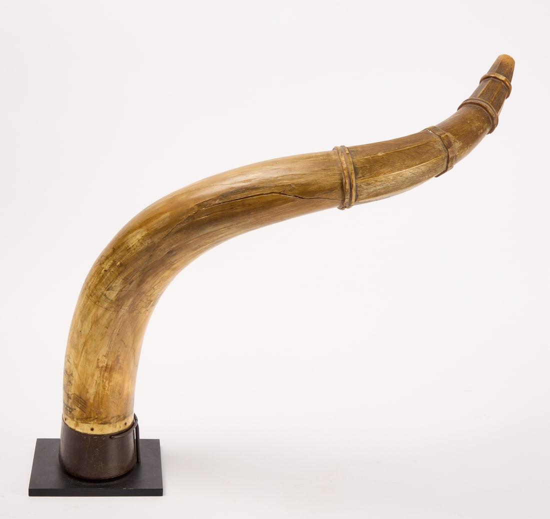 Large Scrimshaw Horn: Scrimshaw horn with ships and a hunter with dogs. Mounted on base.L 27-3/4". H (when on base): 20-1/4".Condition: Crack/break half way down horn, otherwise excellent condition.Link for high-res images
